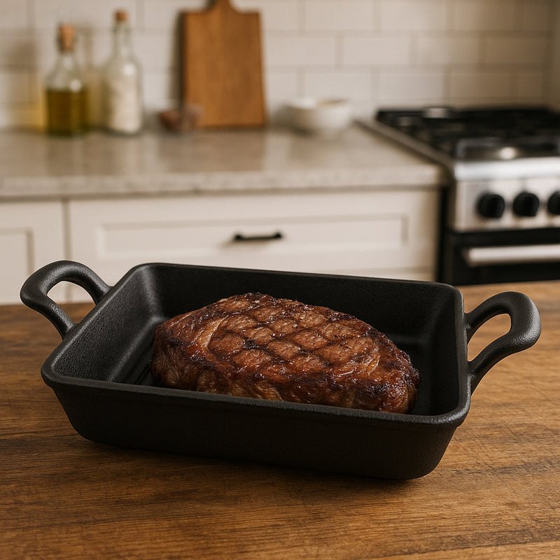 REGENT COOKWARE CAST IRON RECTANGULAR PAN WITH 2 HANDLES ON A WOODEN BOARD, (215X125X65MM)