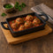 REGENT COOKWARE CAST IRON RECTANGULAR PAN WITH 2 HANDLES ON A WOODEN BOARD, (215X125X65MM)