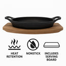 REGENT COOKWARE CAST IRON OVAL PAN WITH 2 HANDLES ON A WOODEN BOARD, (225X120X55MM)