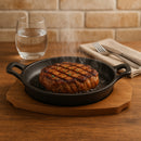 REGENT COOKWARE CAST IRON OVAL PAN WITH 2 HANDLES ON A WOODEN BOARD, (225X120X55MM)