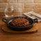REGENT COOKWARE CAST IRON OVAL PAN WITH 2 HANDLES ON A WOODEN BOARD, (225X120X55MM)