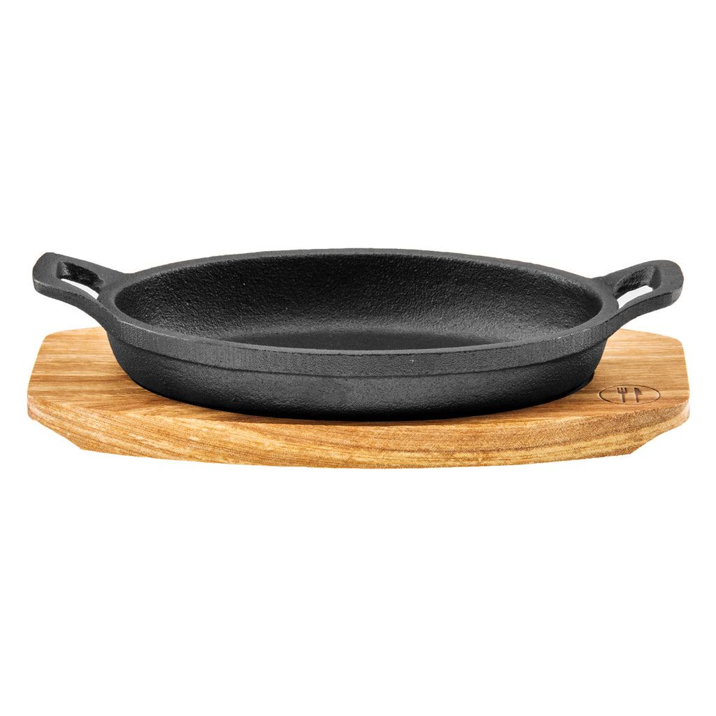 REGENT COOKWARE CAST IRON OVAL PAN WITH 2 HANDLES ON A WOODEN BOARD, 225X120MM